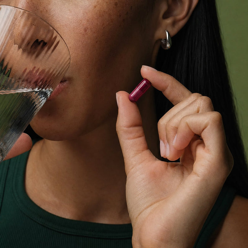 A woman taking a Relivaid capsule with water